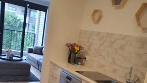 Una cucina moderna con lavastoviglie, lavello e un vaso di fiori sul piano di lavoro.