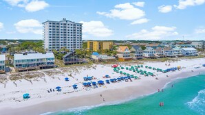 A beach with a hotel, clear turquoise waters, and a sandy shore. - Gulf Views - Beach Chair Service - Zero Entry Pool + Hot Tub - Beach Resort 403 (Miramar Beach)
