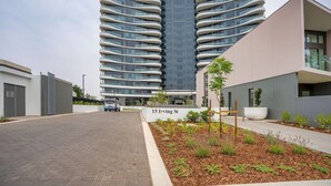 Un bâtiment moderne doté de balcons incurvés et d’une enseigne indiquant « 15, rue Irving ».