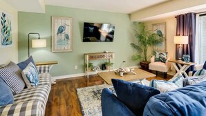 A living room with a sofa, coffee table, TV, and decorative items. - Luxury Villa Golf Beach & Pool Access Hilton Head (Hilton Head Island)
