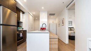Una cocina moderna con una isla central, electrodomésticos de acero inoxidable y muebles de madera.