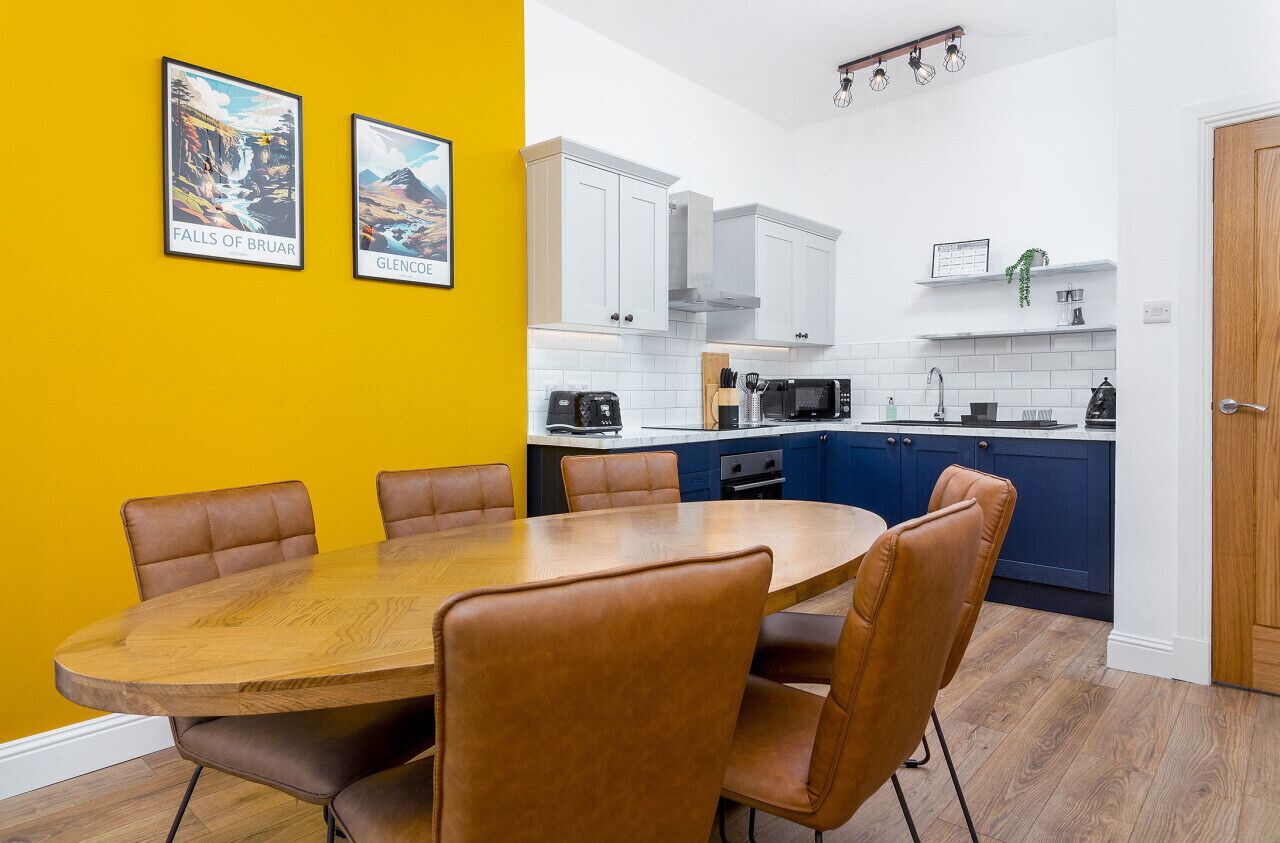 A modern kitchen with white cabinets, a microwave, and a sink.
