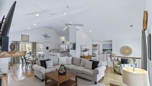 A spacious living area with a large sofa set, a wooden coffee table, and a ceiling fan. - Corolla vacation rental in a gated golf course community, with beach trolley! (Corolla)