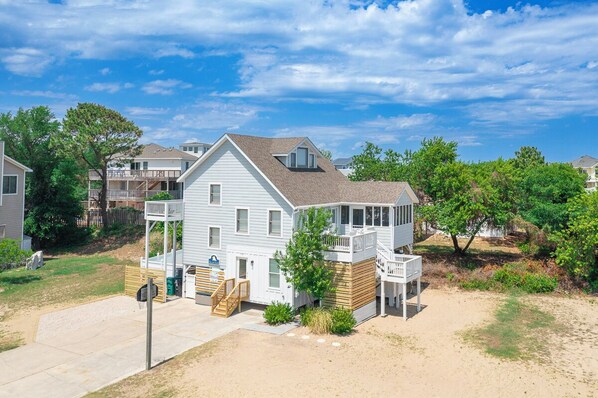 A two-story house with a balcony, a front porch, and a small deck. - Sun Realty oceanside classic in the heart of Duck, NC (Duck)