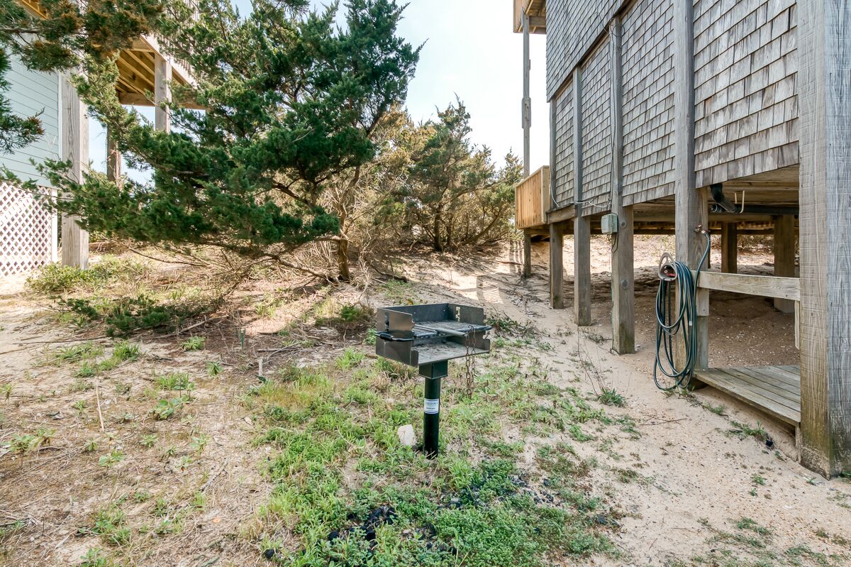 Un bâtiment en bois doté d’un espace extérieur abrité, d’une structure métallique et d’un vélo.