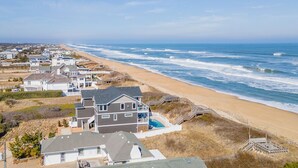 Una zona residencial costera con casas, una playa y vistas al océano.