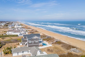 Una zona residencial costera con casas, una playa y vistas al océano.