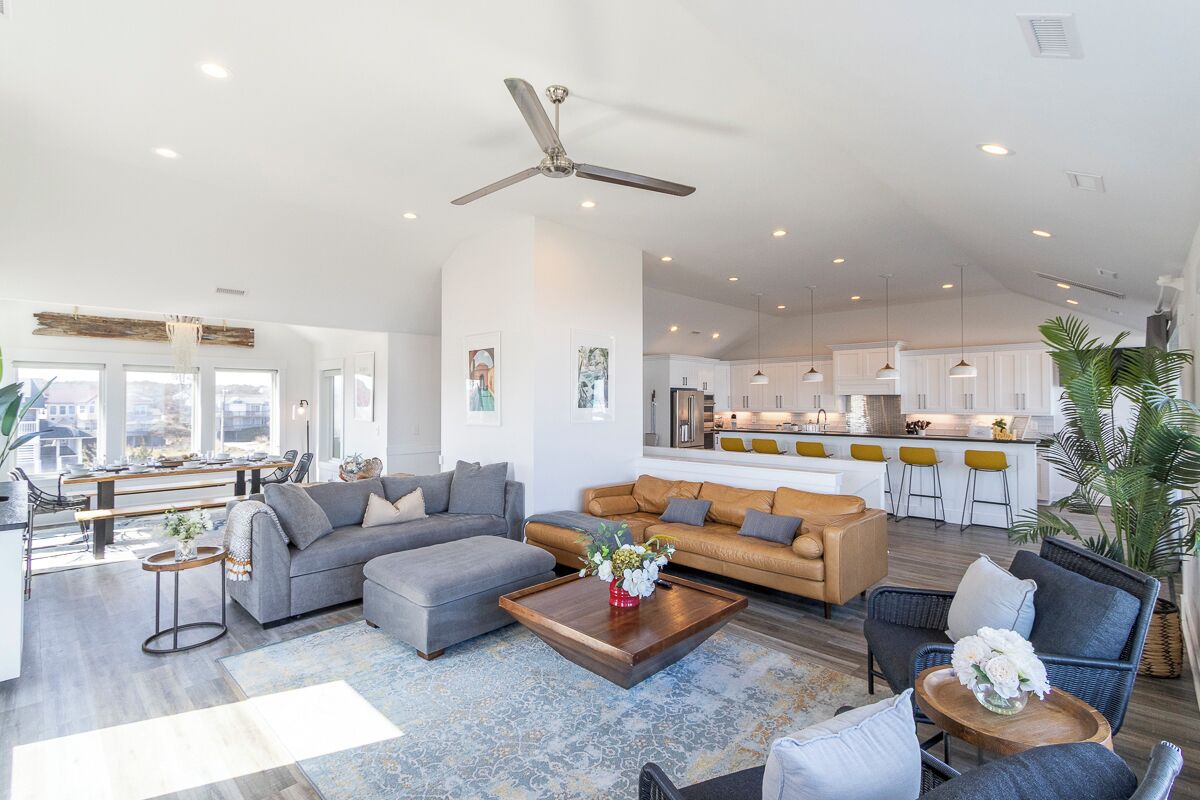 A spacious living room with a large sofa, a coffee table, and a dining area with a bench.