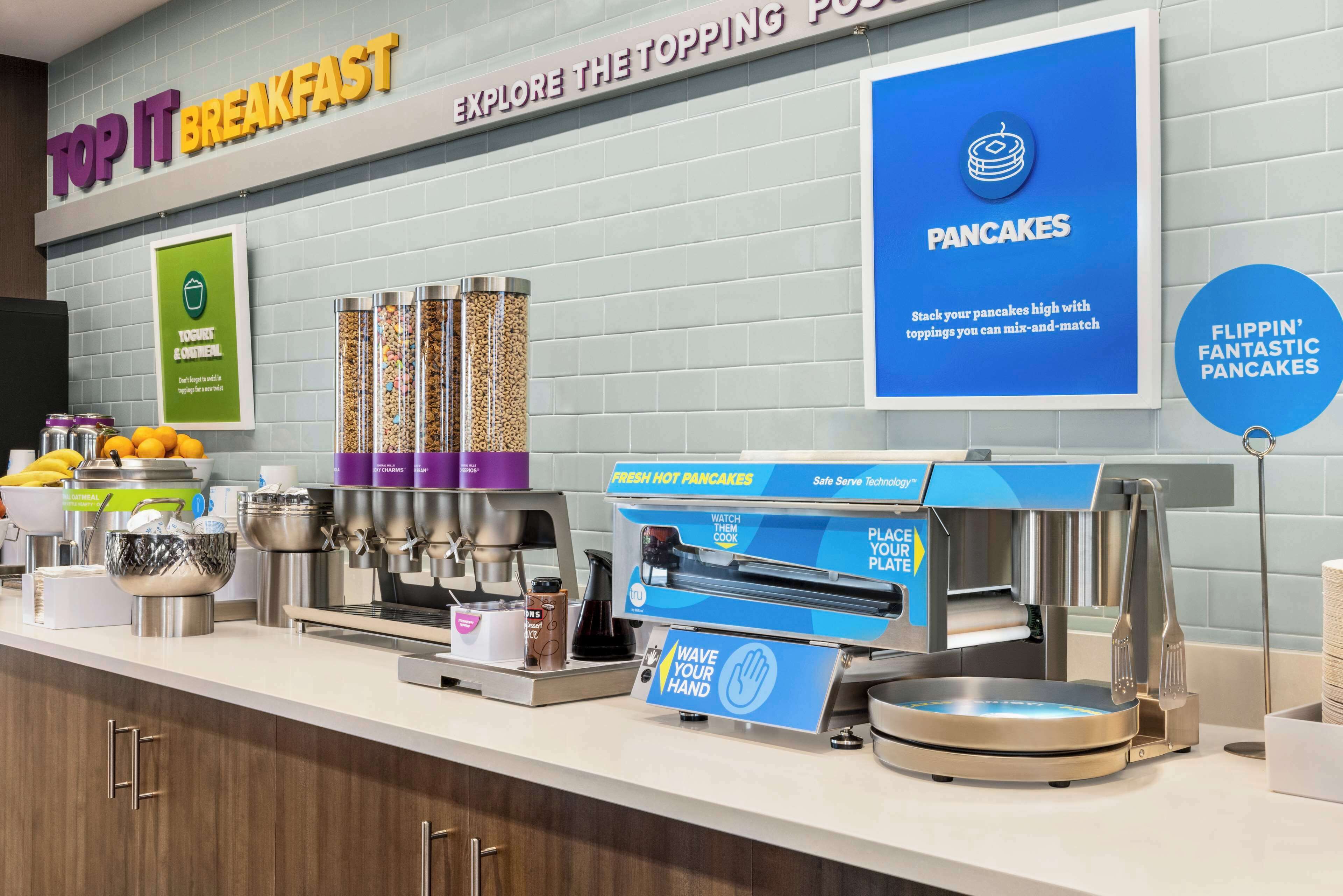 A breakfast station with a sign for 'Top It Breakfast' and 'Explore the Topping Pot'.