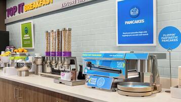 A breakfast station with a sign for 'Top It Breakfast' and 'Explore the Topping Pot'.