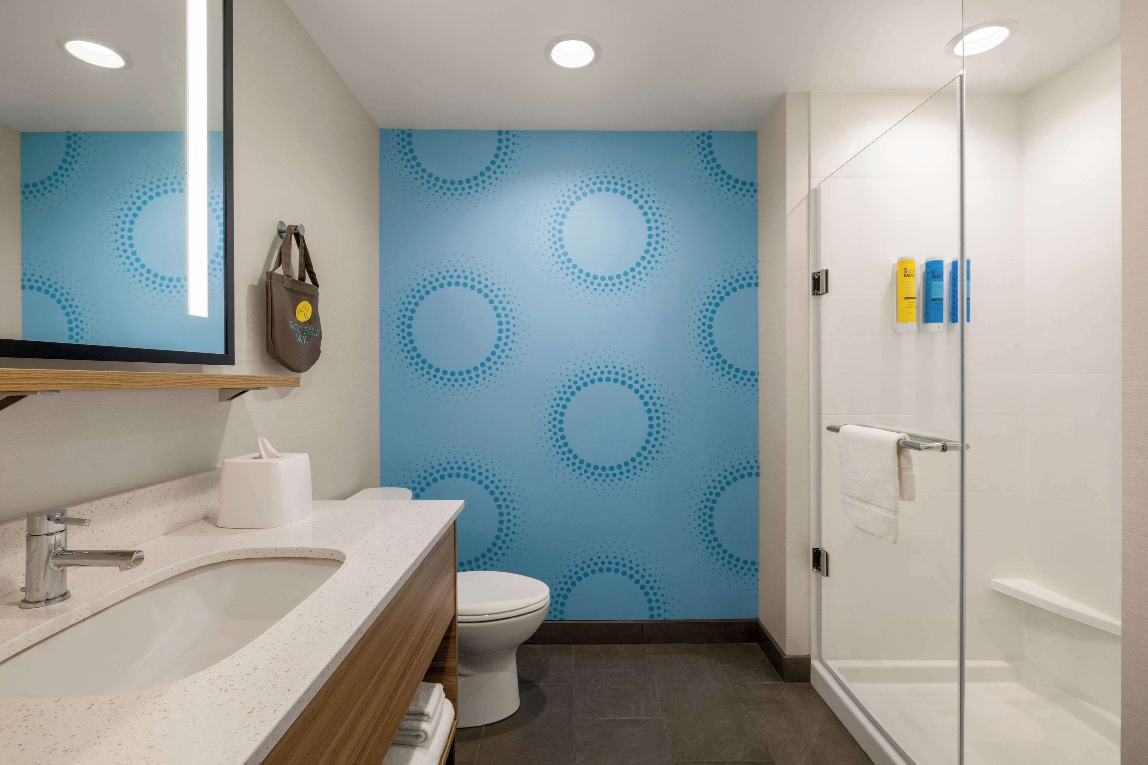 A modern bathroom with a large sink, toilet, and shower area.