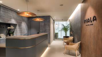 Welcome to INALA's reception area, featuring a curved reception desk and comfortable seating for guests to relax.