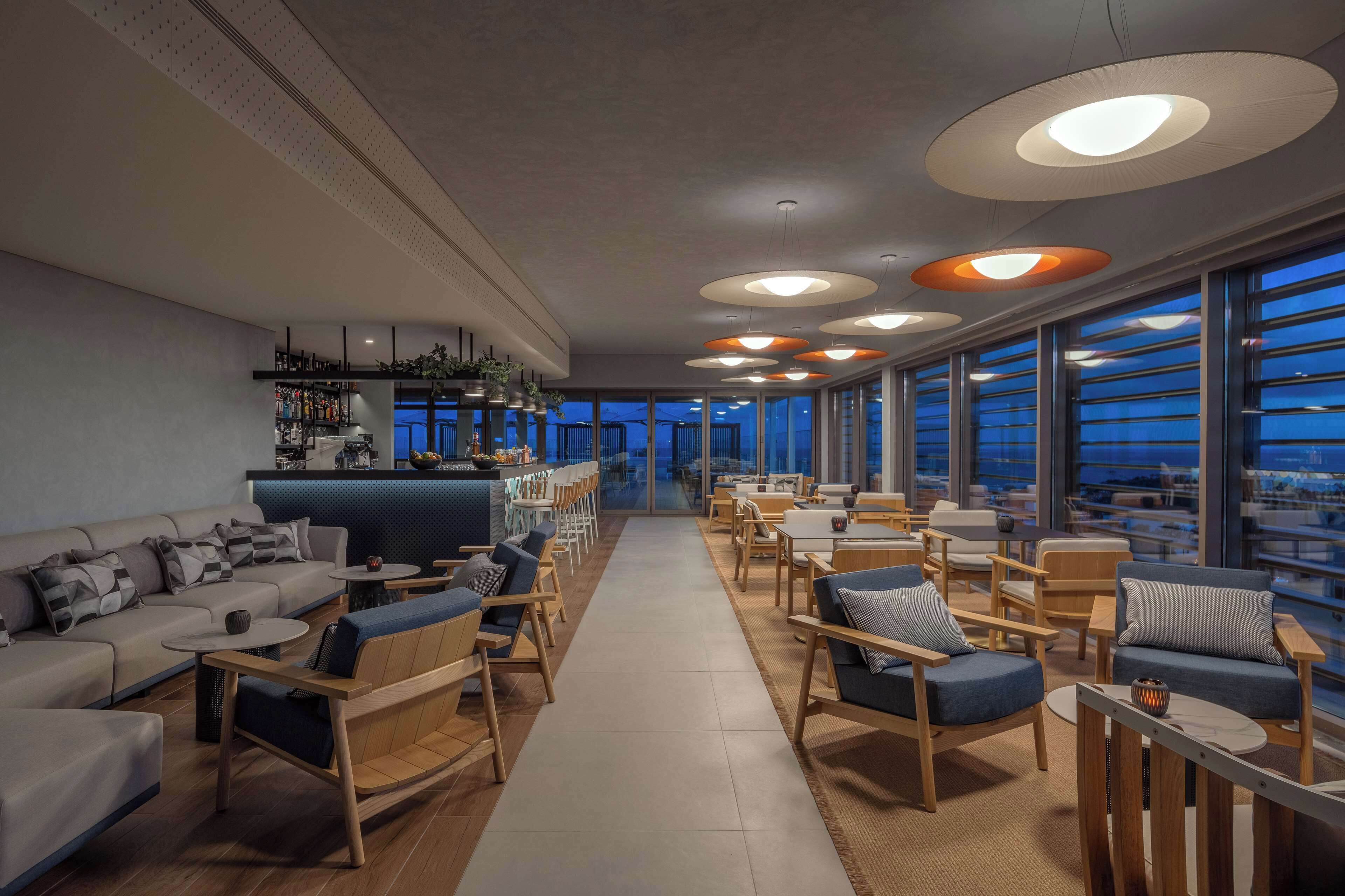 Un espace de détente moderne avec des canapés, des fauteuils et un bar.