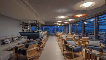 Un espace de détente moderne avec des canapés, des fauteuils et un bar.