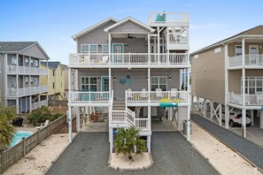 A multi-story beachfront property with balconies, a pool, and a beachside view. - Rainbow Skies- 5 bedroom, 4 bath w/private pool, OIB resort & steps to the beach (Ocean Isle Beach)