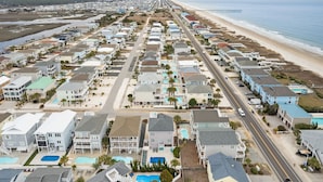 A coastal residential area with houses, a beach, and a pier. - Rainbow Skies- 5 bedroom, 4 bath w/private pool, OIB resort & steps to the beach (Ocean Isle Beach)