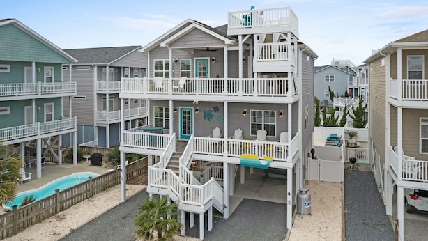 A multi-story residential building with a balcony, a swimming pool, and a small deck area. - Rainbow Skies- 5 bedroom, 4 bath w/private pool, OIB resort & steps to the beach (Ocean Isle Beach)