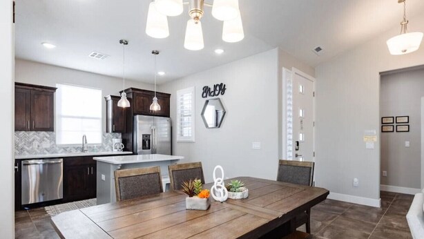 A modern kitchen with dark cabinets, stainless steel appliances, and pendant lighting. - 3 Bed Single Floor Sleeps w/pool (Washington)