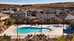 A residential area with a swimming pool surrounded by houses, a fenced patio area, and a hilly landscape in the background. - 3 Bed Single Floor Sleeps w/pool (Washington)