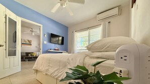 A bedroom with a bed, a ceiling fan, a TV, and a potted plant. - ATTENTION: Frequent Island wide power outages likely! Summer/Fall 2026. (Nassau)