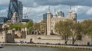 A historic castle with a moat, a modern glass building, and a river. - Contemporary flat in the City (London)
