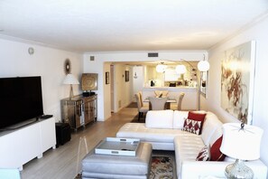 Relax in this stylish living room with a flat-screen TV, comfortable sofa, and dining area.