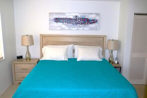 Relax in comfort with a large bed, two nightstands, and a stylish wall art above.