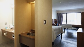 Una camera d'albergo con bagno, un letto, una scrivania e una finestra.