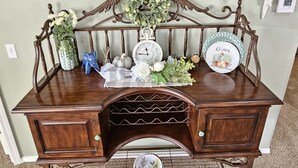 A vintage wooden desk with a clock, decorative plates, and a floral arrangement. - Fairways Oasis Walk-in Suite at the Fairways at Thousand Hills! Great Rates! (Branson)
