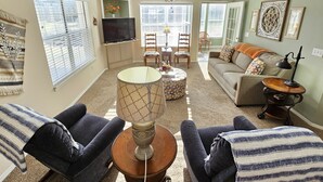 A living room with a sofa, chairs, a coffee table, a TV, and a ceiling fan. - Fairways Oasis Walk-in Suite at the Fairways at Thousand Hills! Great Rates! (Branson)
