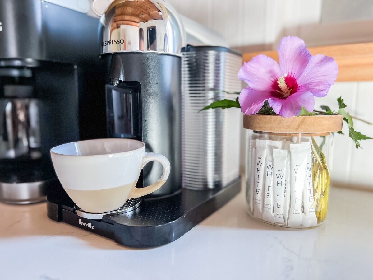 Een koffiezetapparaat, een kop en een pot met koffiehoeveelheden.