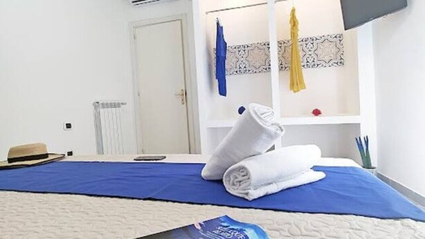 Une chambre d’hôtel équipée d’un lit, d’un téléviseur à écran plat fixé au mur, d’un porte-serviettes avec des serviettes et d’un radiateur.