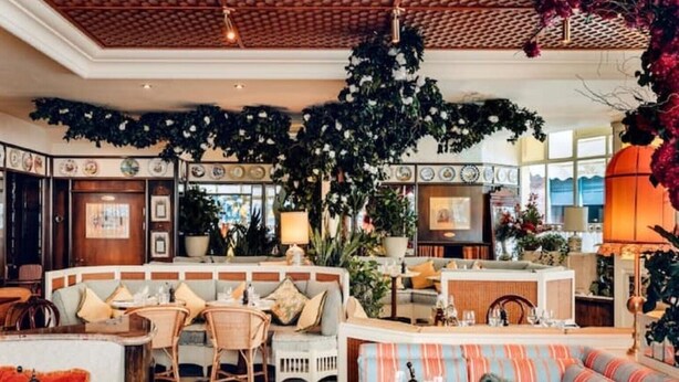 A hotel lobby with a central seating area, a reception desk, and a bar. - Ideally located cosy flat (London)