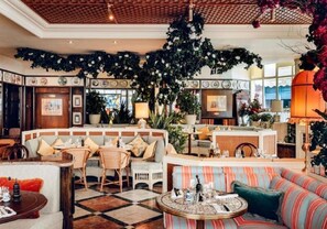 A hotel lobby with a central seating area, a reception desk, and a bar. - Ideally located cosy flat (London)