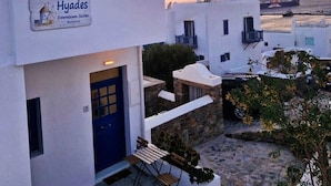 A white building with a blue door and a sign reading "Hyades Downtown Suites Mykonos." - Hyades - Downtown Suites No 3 , Mykonos Town (Mykonos, Cyclades)