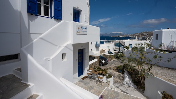 A white building with blue shutters and a sign reading "Hyades Downtown Suites." - Hyades - Downtown Suites No 3 , Mykonos Town (Mykonos, Cyclades)