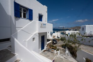 Un edificio blanco con contraventanas azules y un letrero que dice "Hyades Downtown Suites".