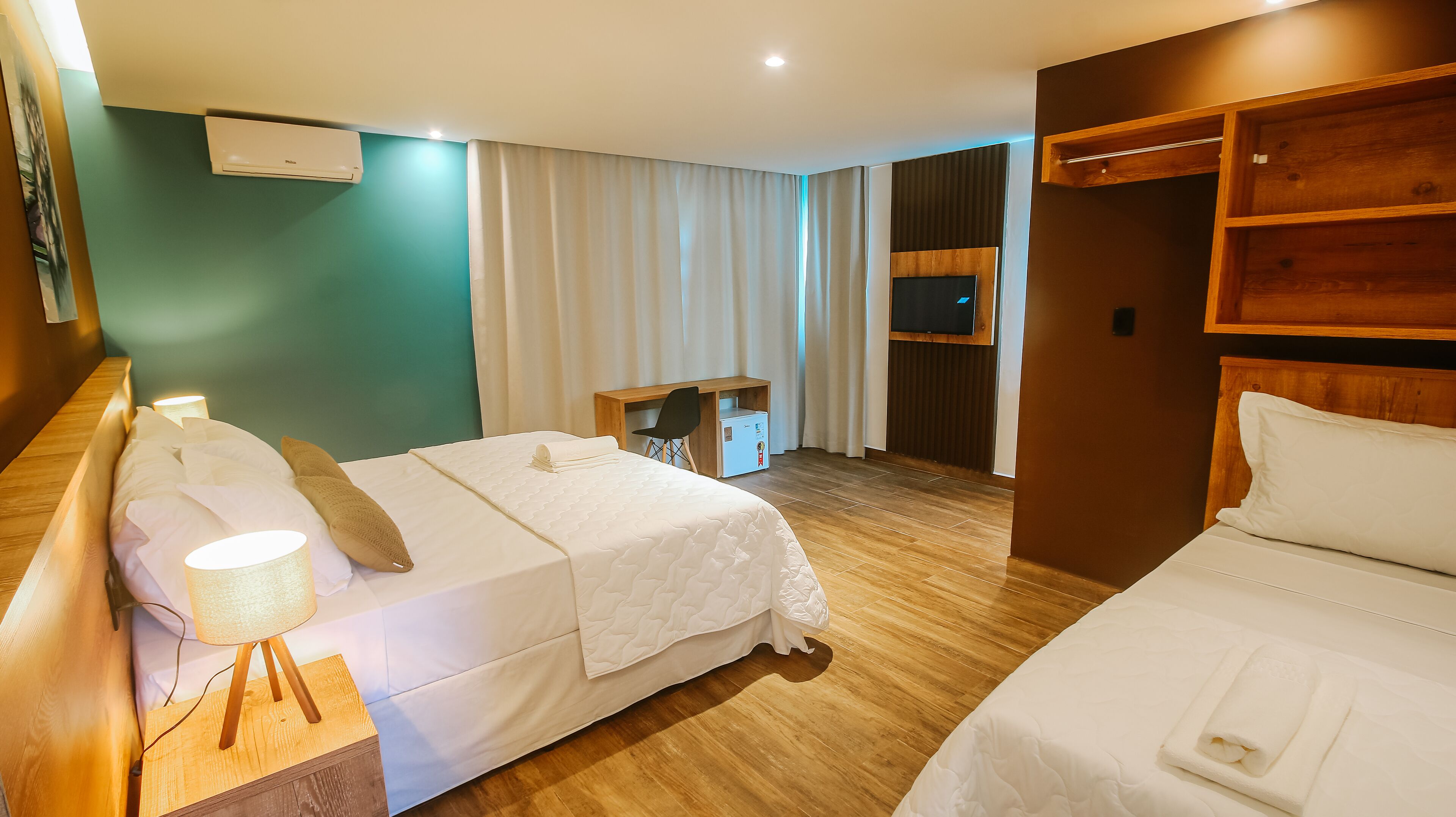 Une chambre d’hôtel avec deux lits, un bureau, une chaise, une télévision et un mini-bar.
