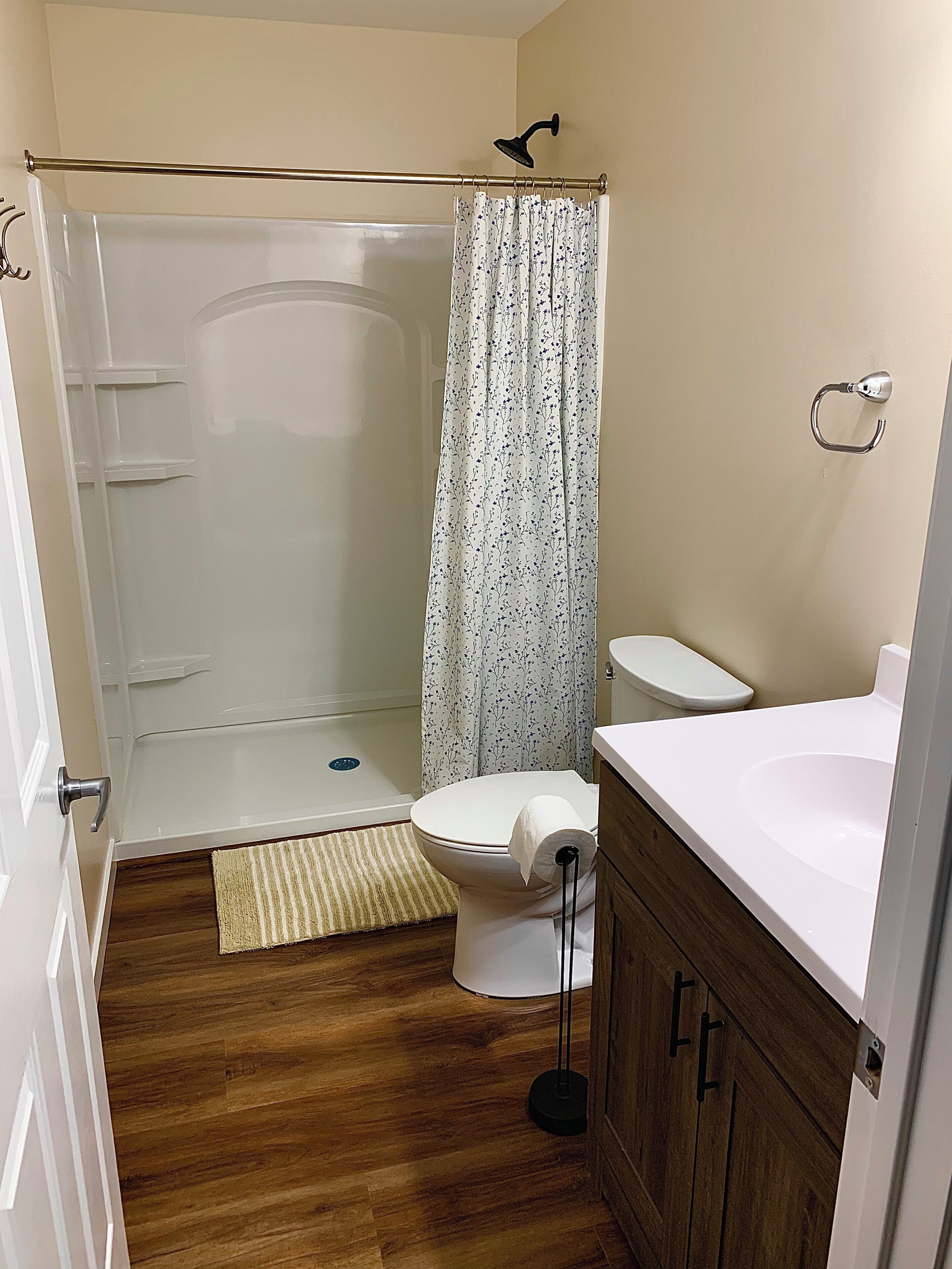 A bathroom with a shower, toilet, and sink.