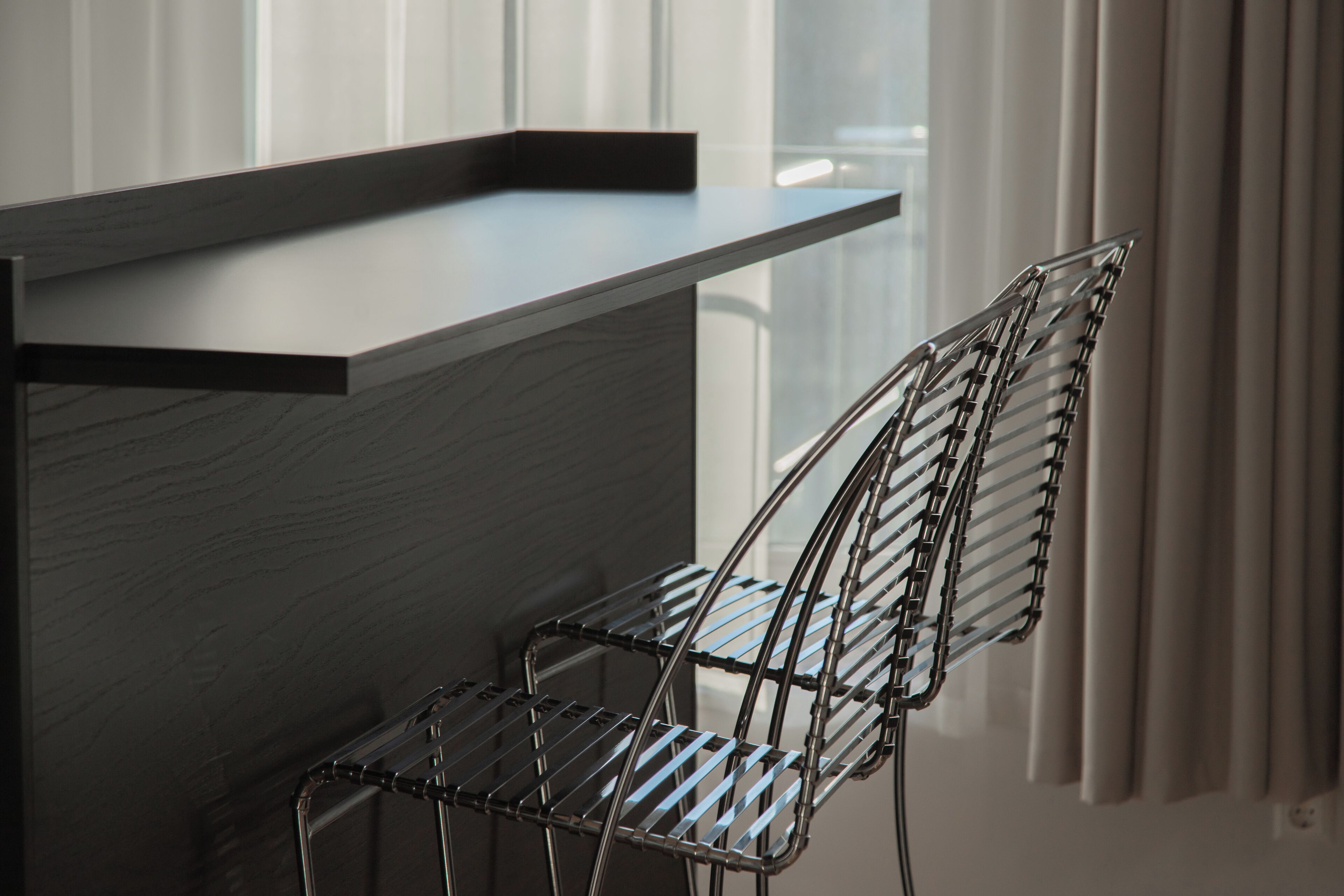 Una cocina moderna con una encimera integrada y una silla de metal.
