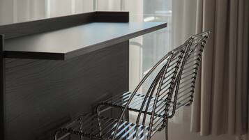 A modern kitchen with a built-in countertop and a metal wire chair.