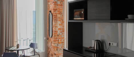 A modern kitchen with a brick accent wall, a dining area with chairs, and a patterned floor.