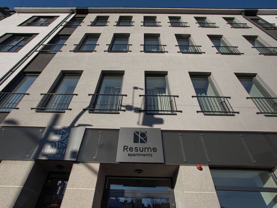 Een gebouw met meerdere ramen en balkons, met de aanduiding 'Resume Apartments'.