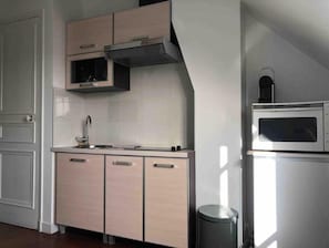 A compact kitchen with a microwave, stove, and sink. - VUE Tour Eiffel Depuis LE Balcon Studio Lumineux Avec VUE SUR LES Toits DE Paris (Paris)