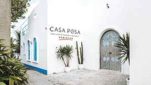 Un bâtiment blanc avec des bordures bleues et une enseigne sur laquelle on peut lire « CASA POSA ».