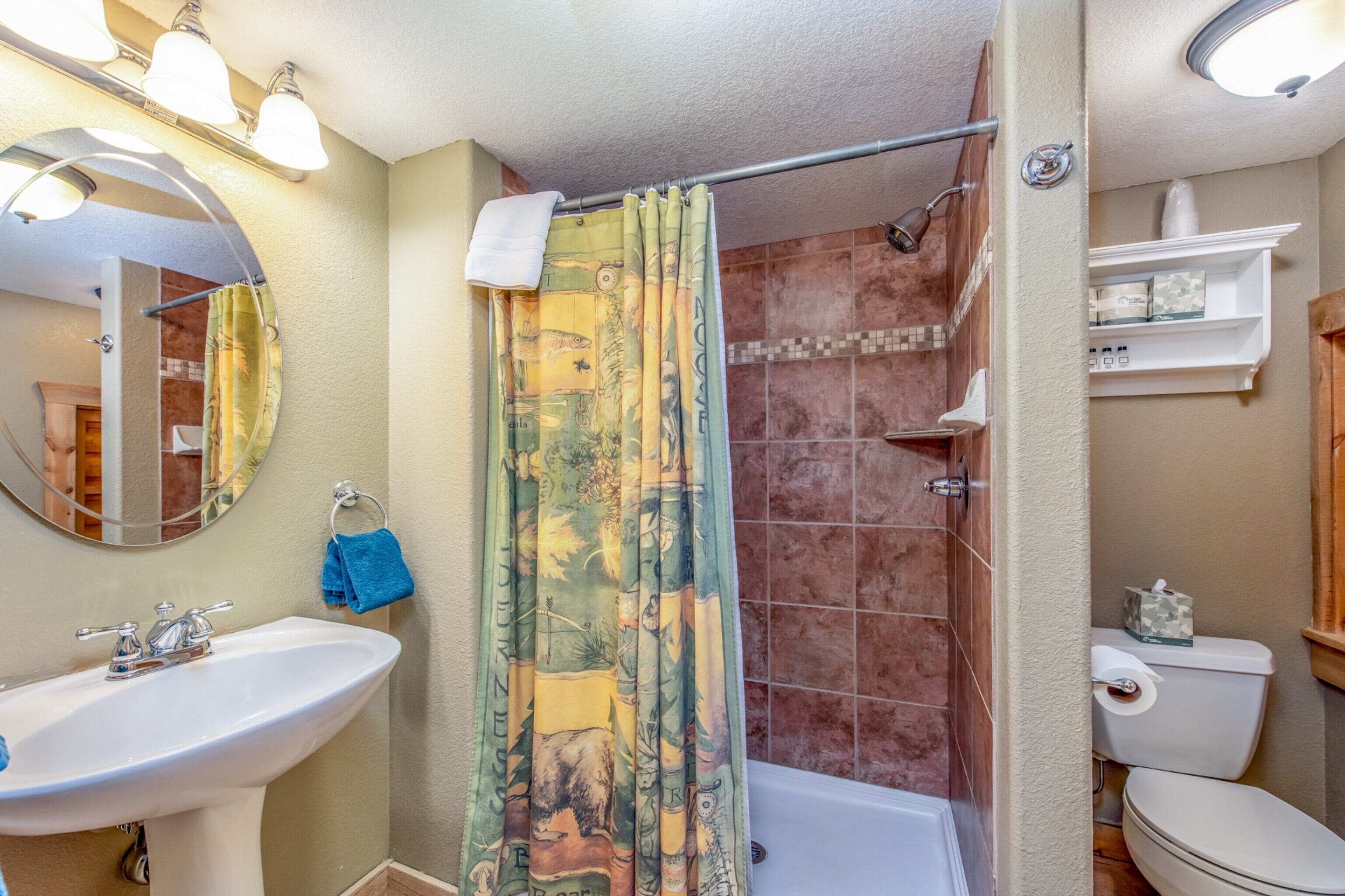 Ein Badezimmer mit Waschbecken, Spiegel, Duschvorhang und Toilette.