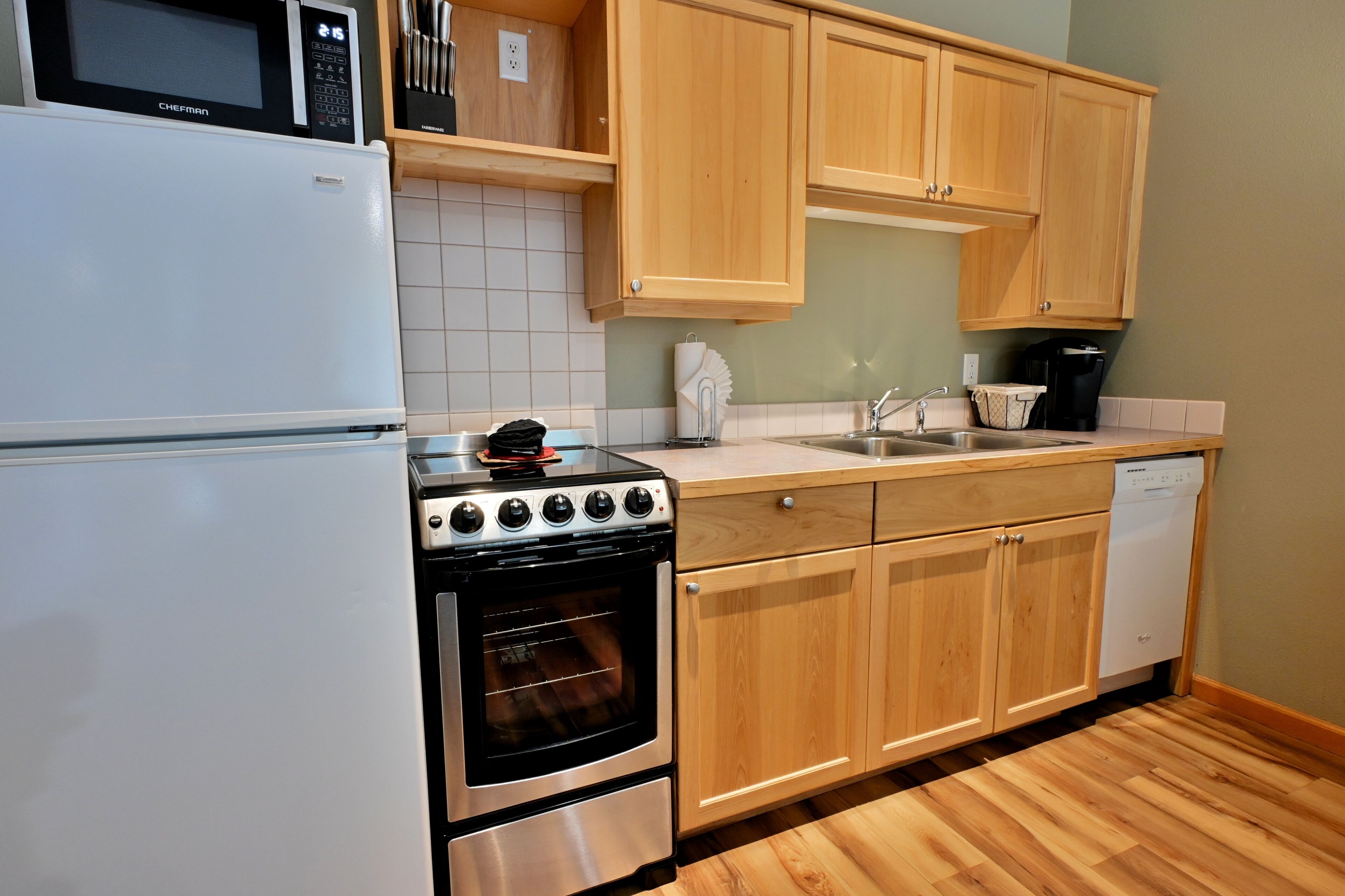 Una cocina equipada con refrigerador, estufa, horno y lavavajillas.