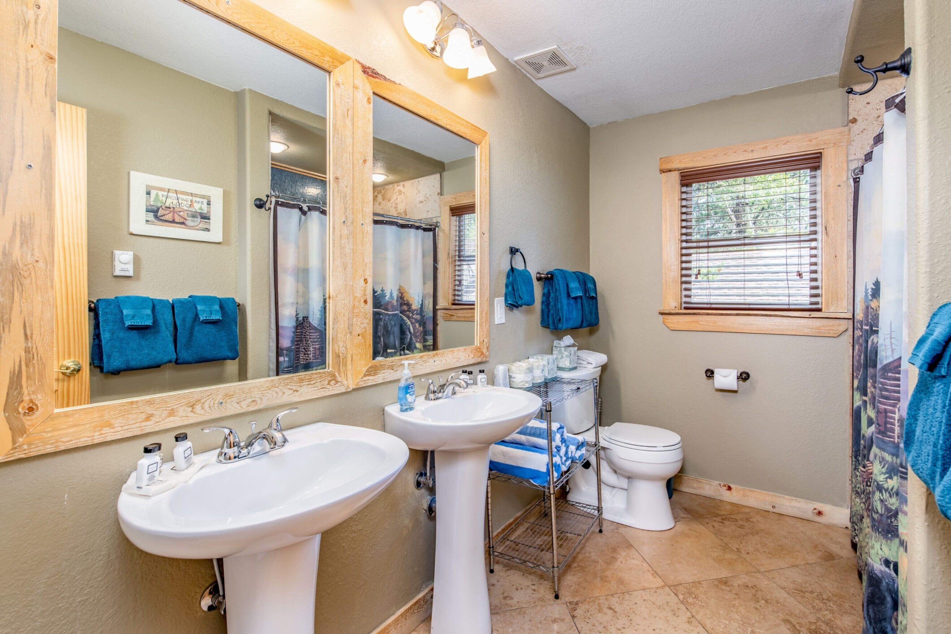 A bathroom with two sinks, a toilet, and a shower.