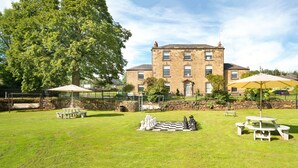 A spacious outdoor area with a large lawn, picnic tables, and a chessboard. - The Old Wine Cellar - 4 bedroom property (Oakerthorpe)