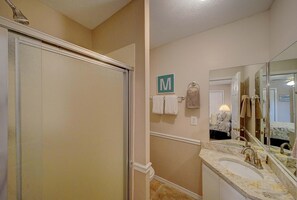 Une salle de bain avec une douche, un lavabo et un miroir.